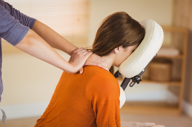 Photo young woman getting massage in chair