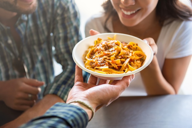 Young woman getting pasta from food truck