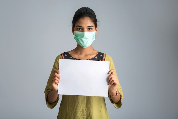코로나 바이러스, Covid-19의 전염병의 보드를 들고 의료 마스크에 젊은 여자 또는 소녀