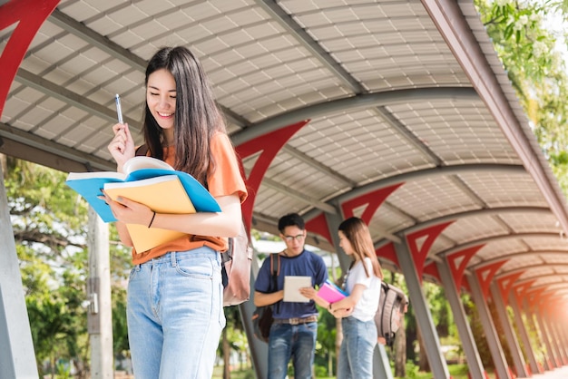 若い女性の女の子、学生はバック グラウンドで大学とクラスメートでメモ帳を保持します。