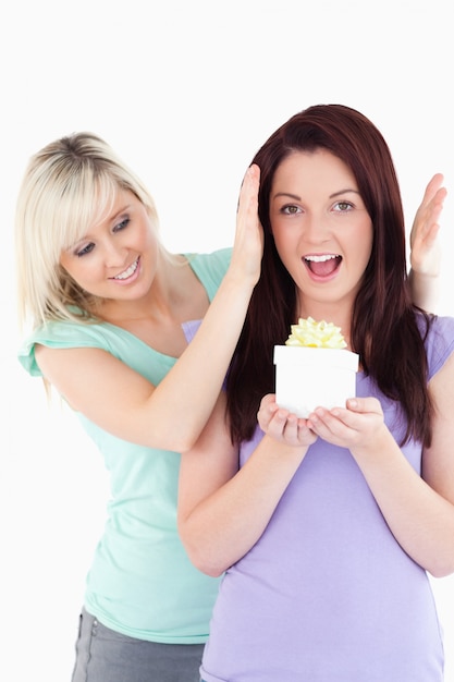 Young woman  giving a gift to her friend