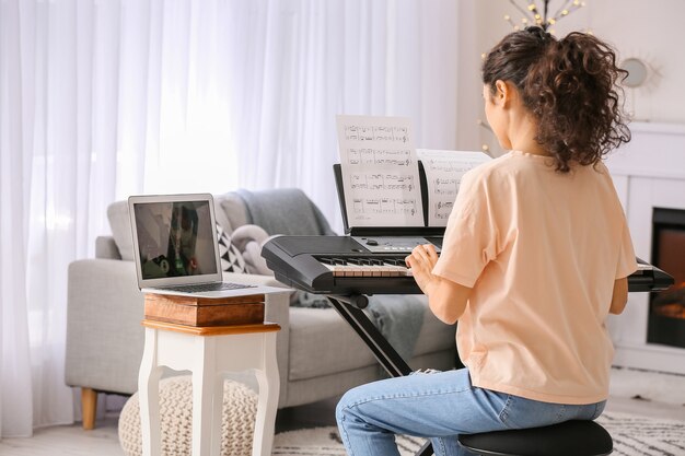 Young woman giving music lessons online at home