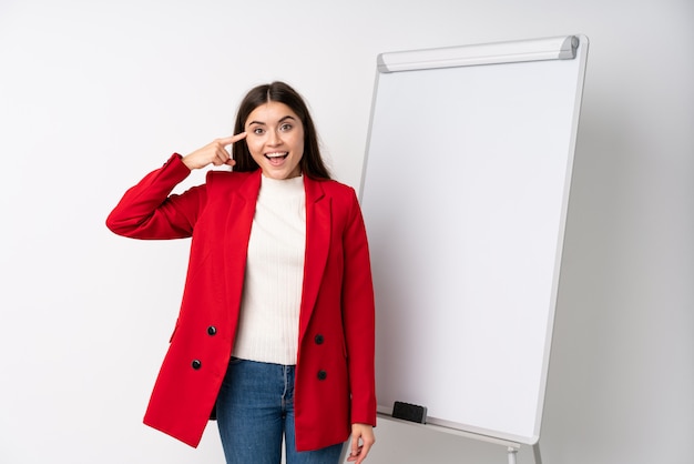 Young woman giving a presentation on white board intending to realizes the solution