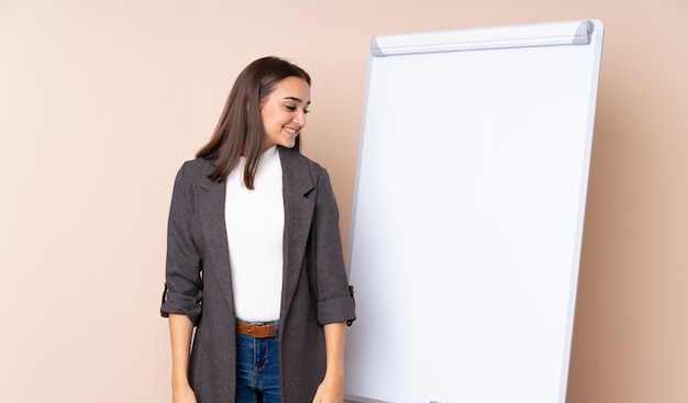 Young woman giving a presentation on white board looking side