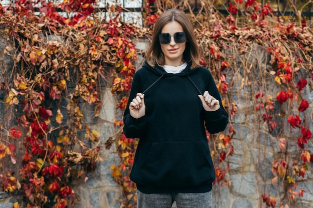 Young woman in glasses and black hoodie