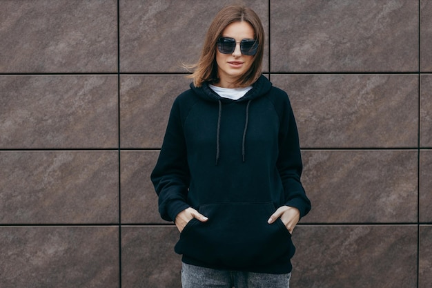 Young woman in glasses and black hoodie