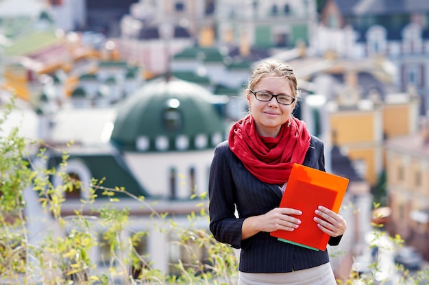 Young woman in glasses with folder in hands