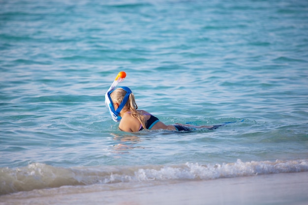 Young woman goes snorkeling in the ocean