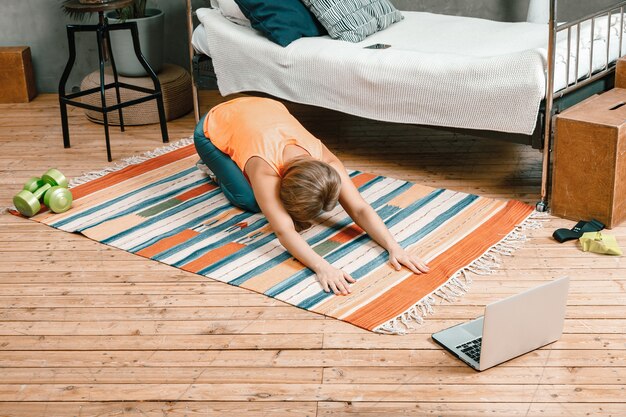 A young woman goes in for sports at home, online workout 