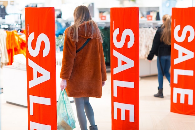 Photo young woman goes through a security anti-theft framework in a store