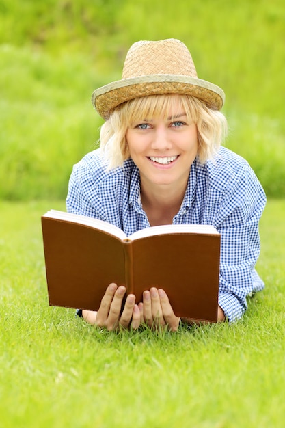 a young woman on a grass with a book