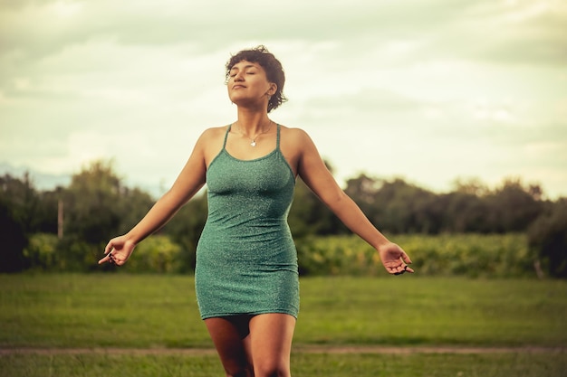 Young woman in green dress posing in nature