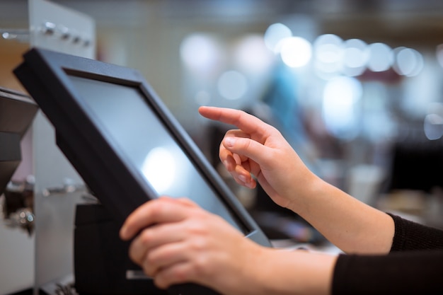 Photo young woman hand doing process payment on a touchscreen cash register, finance concept