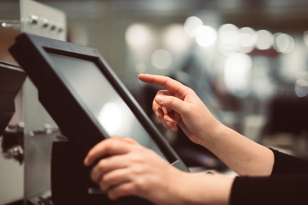 young woman hand doing process payment on a touchscreen cash register, finance concept