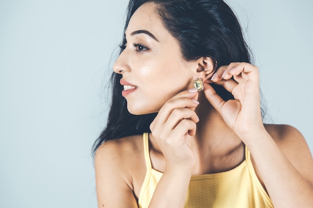 Young woman hand earring in ear