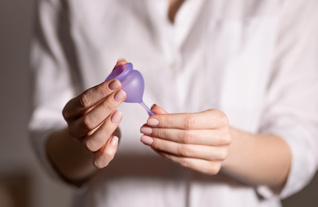 Young woman hand holding menstrual cup Selective focus and shallow DOF