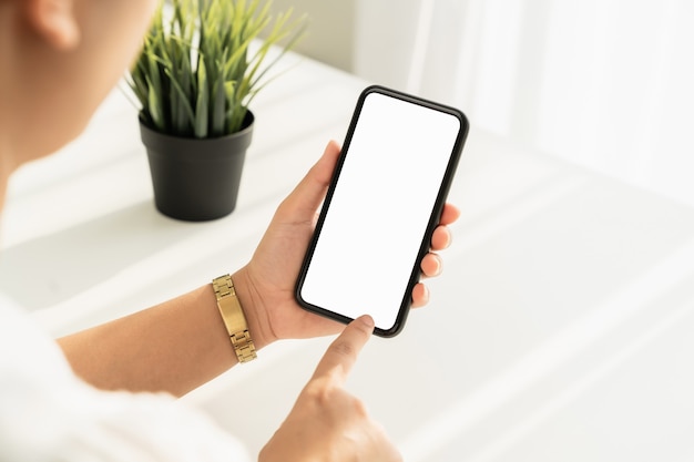 young woman hand holding smartphone on the table and the screen is blank, social network concept.