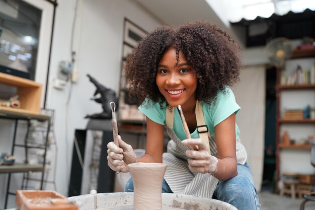 Young Woman hand potter making clay vase in pottery workshop Business owner