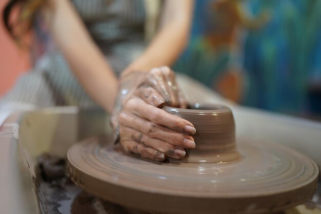 Young woman hand potter making clay vase in pottery workshop\
business owner