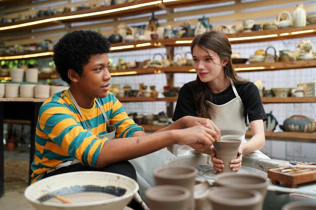 Young woman hand potter making clay vase in pottery workshop\
business owner