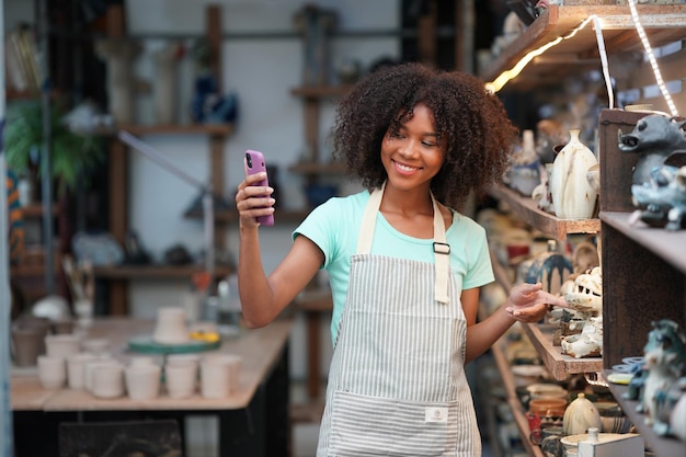 Young Woman hand potter making clay vase in pottery workshop Business owner