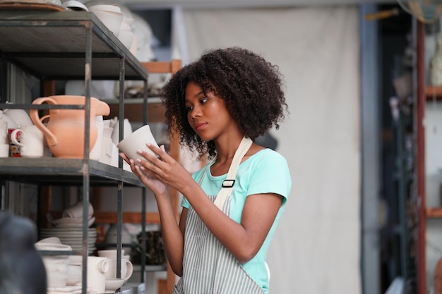 Young Woman hand potter making clay vase in pottery workshop Business owner