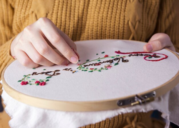 Photo young woman hands are embroidered happy valentines day