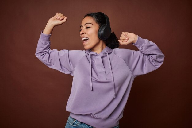 Young woman happily enjoying music on mobile with headphones