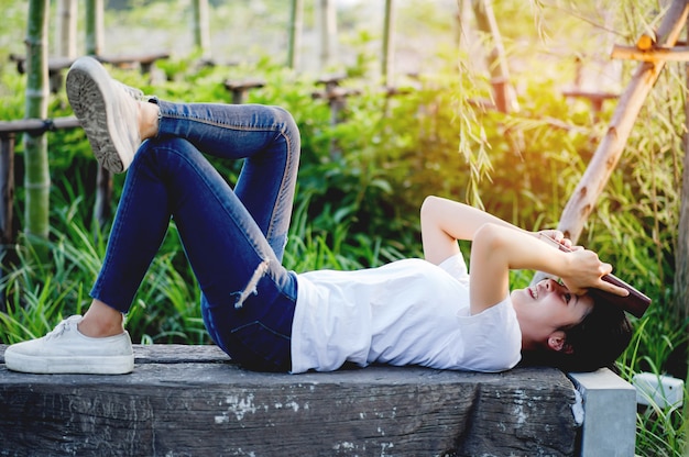 Young woman happily reading the book in nature