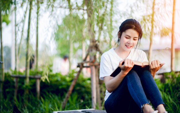 Young woman happily reading the book in nature