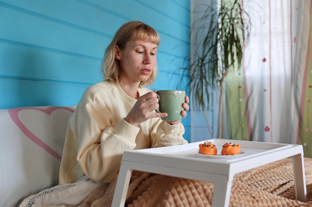 Young woman has breakfast in bed