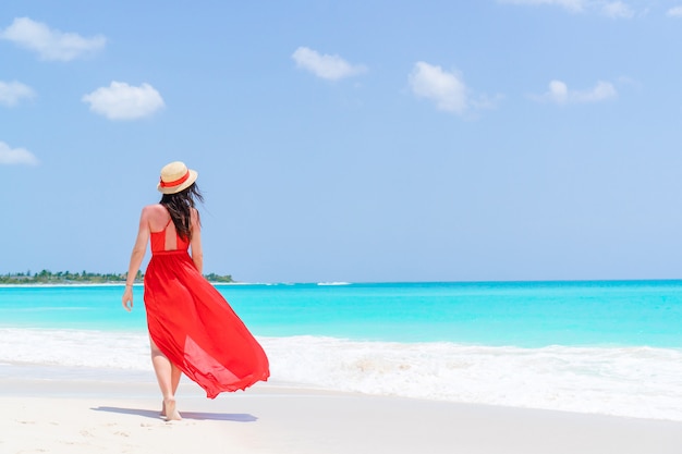 Giovane donna con cappello durante le vacanze di spiaggia tropicale