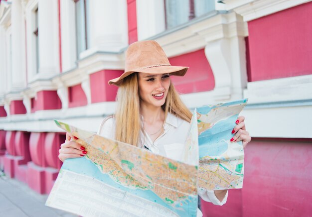 Young woman in hat looking at the city map