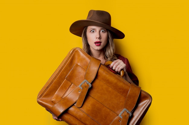 Young woman in hat with suitcase 