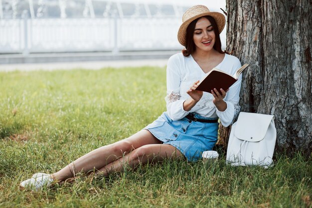 Young woman have weekend and sits in the park at daytime