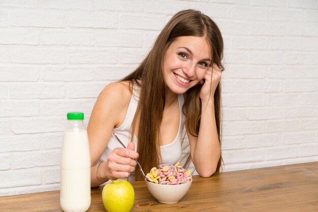 Young woman having breakfast with bowl of cereals