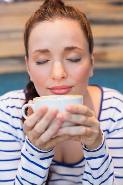 Foto giovane donna con un cappuccino