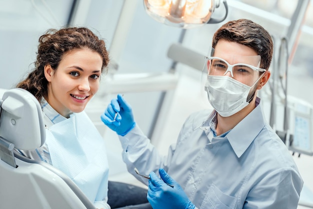 Young woman having check up and dental exam at dentist Side view