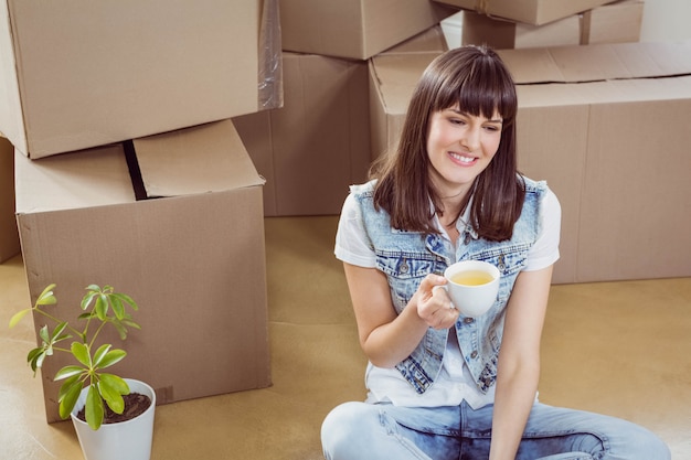 Young woman having coffee in her new house