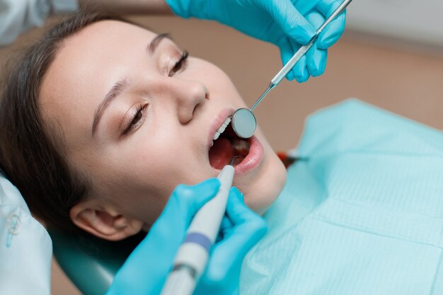 young woman having dental treatment at dentists office