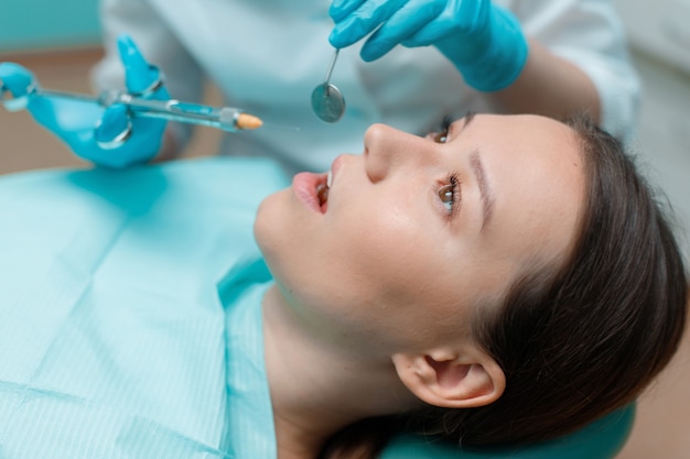 young woman having dental treatment at dentists office