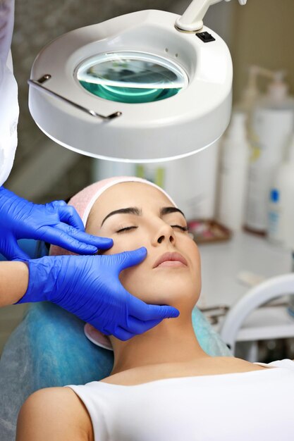 Photo young woman having face massage in a beauty salon