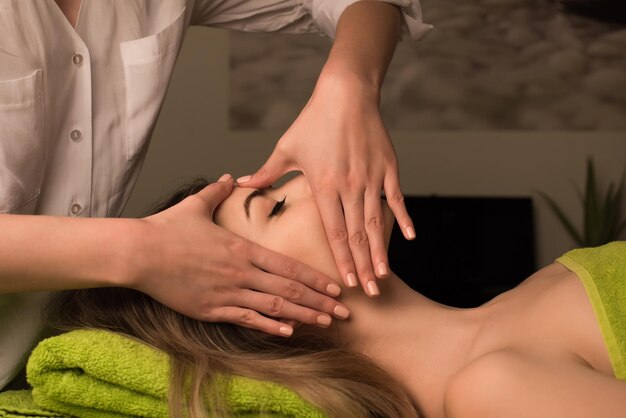 Young woman having a facial massage at the spa