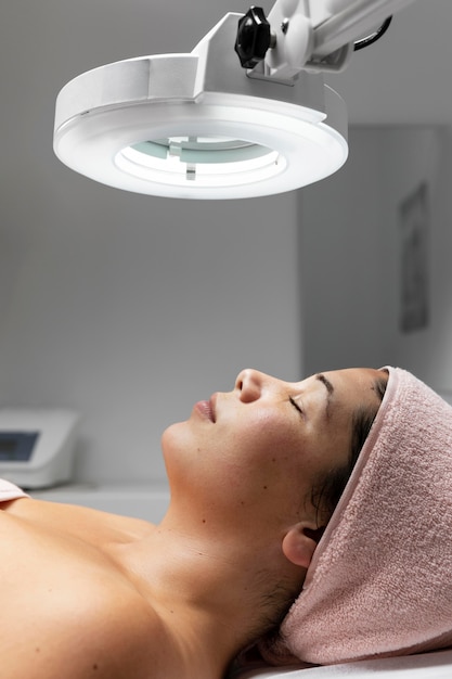 Photo young woman having a facial treatment at the beauty salon