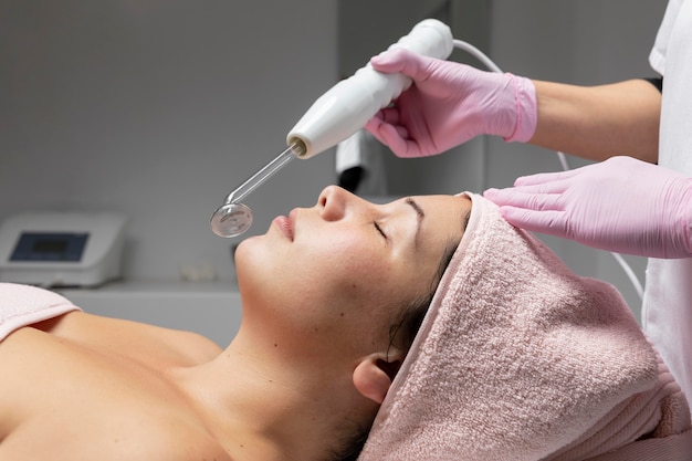 Photo young woman having a facial treatment at the beauty salon