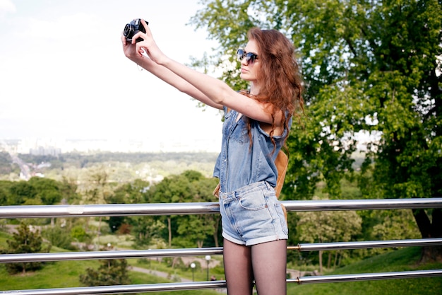 自然の中で楽しんで写真を作る若い女性