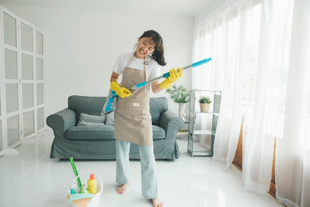 Young woman having fun while cleaning at home