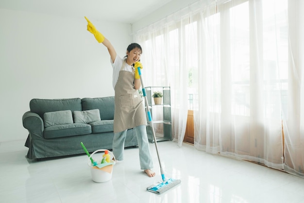 Young woman having fun while cleaning at home