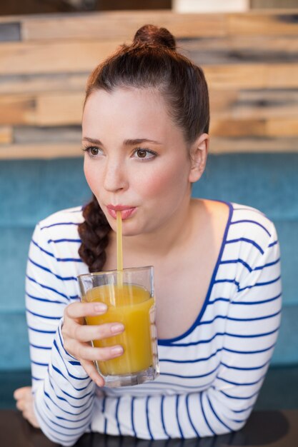 Young woman having glass of orange juice