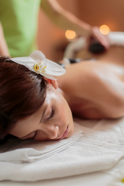 Young woman having a hot stone massage therapy